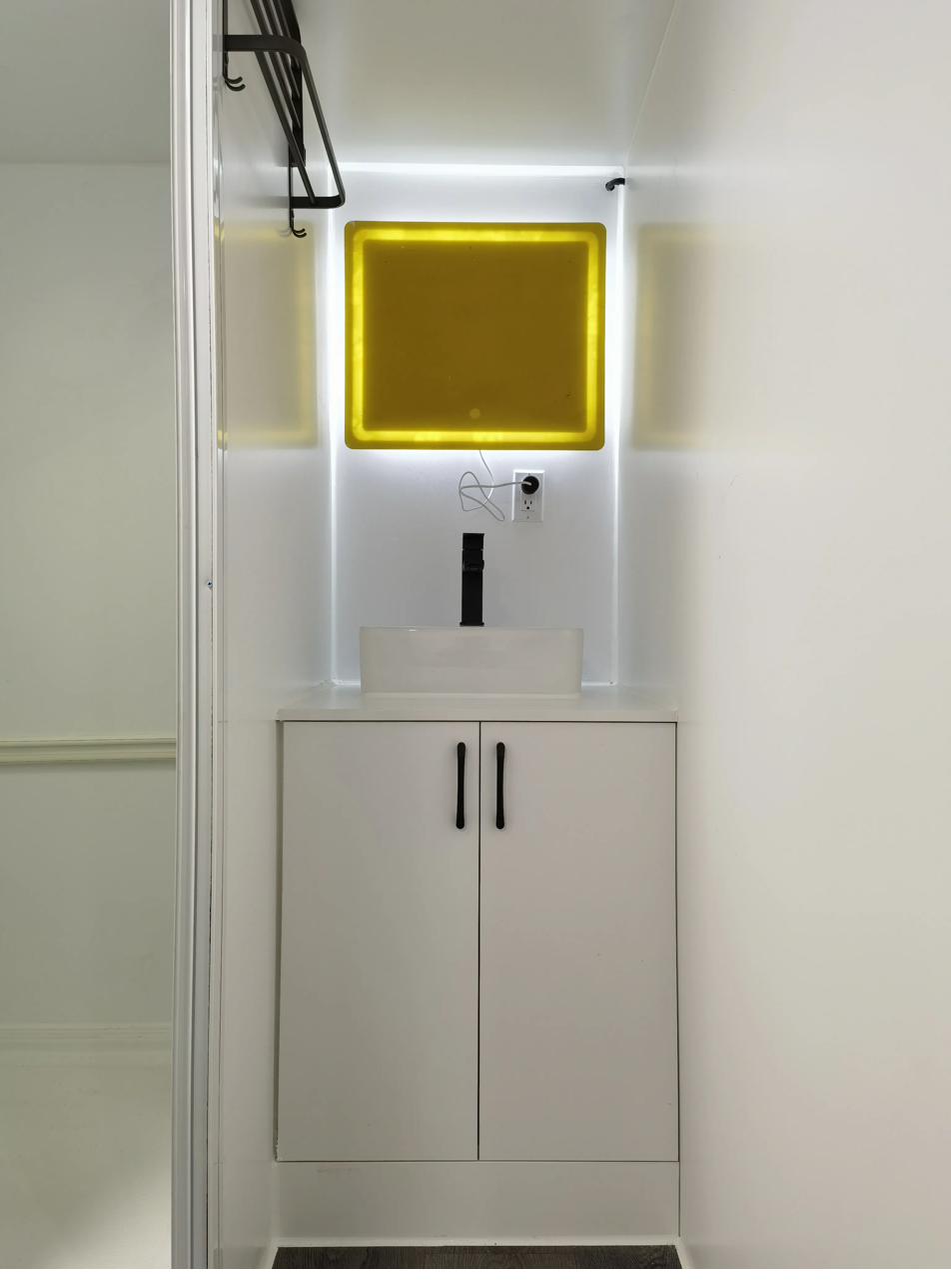Expandable 20ft tiny house bathroom — vessel sink with LED accent mirror and modern vanity