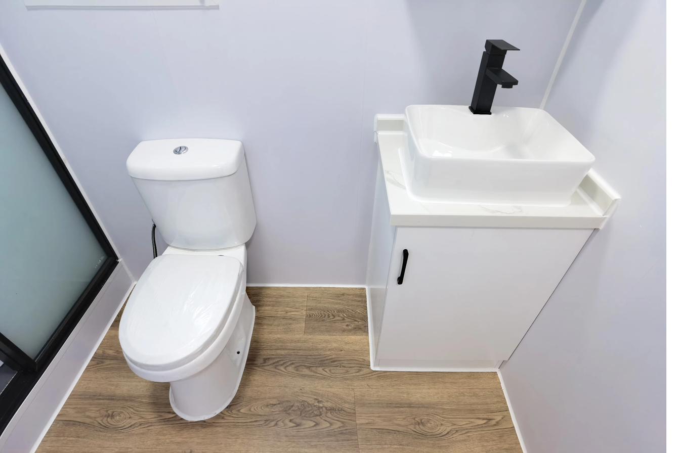 Premium 40ft tiny house bathroom — complete white bathroom with toilet, vessel sink, black fixtures