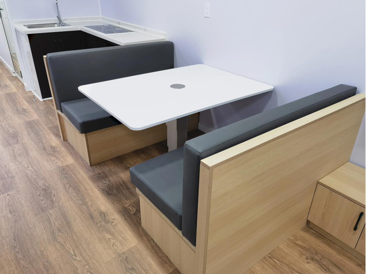 Premium 40ft tiny house dining banquette with built-in storage and adjacent kitchen